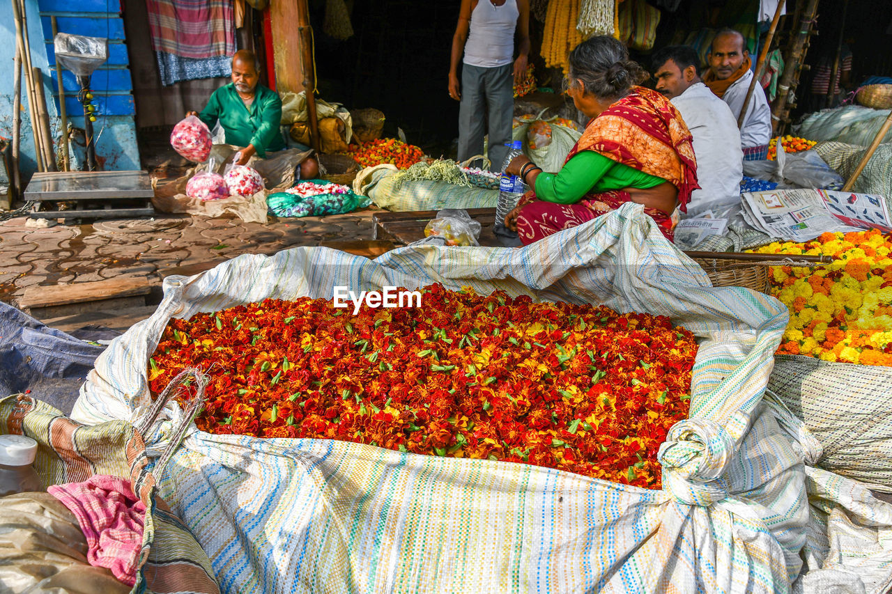 PEOPLE IN MARKET STALL