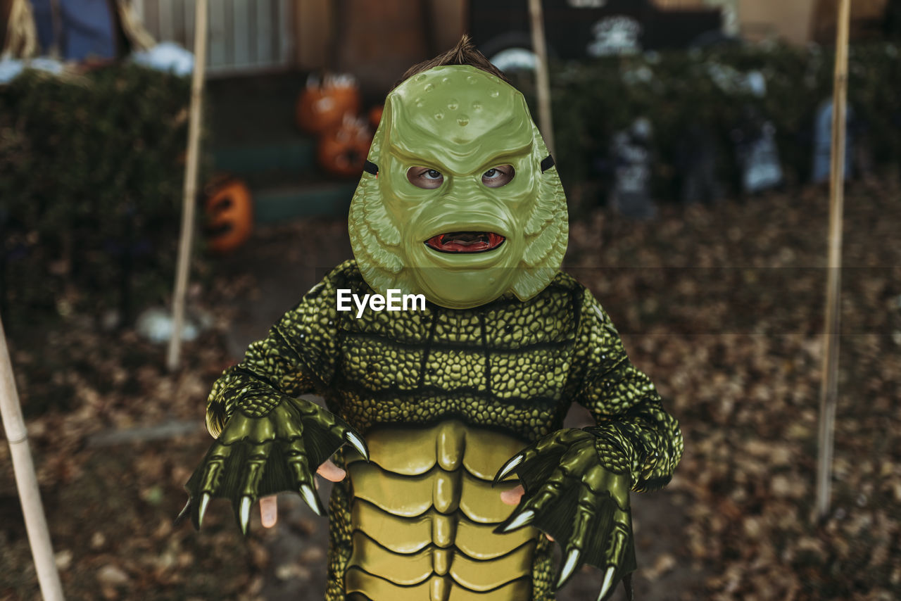 Young boy dressed as sea monster posing in costume at halloween