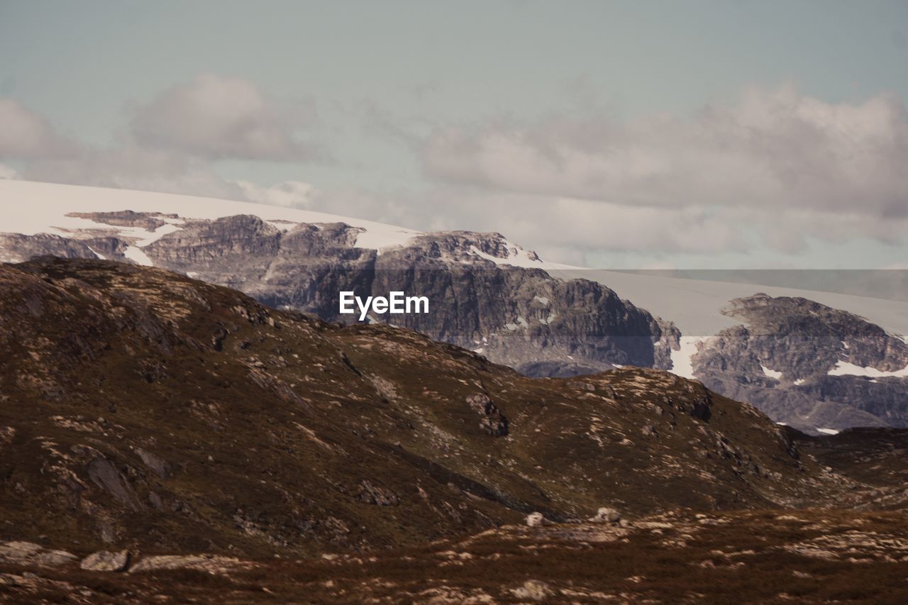 Scenic view of mountains against cloudy sky