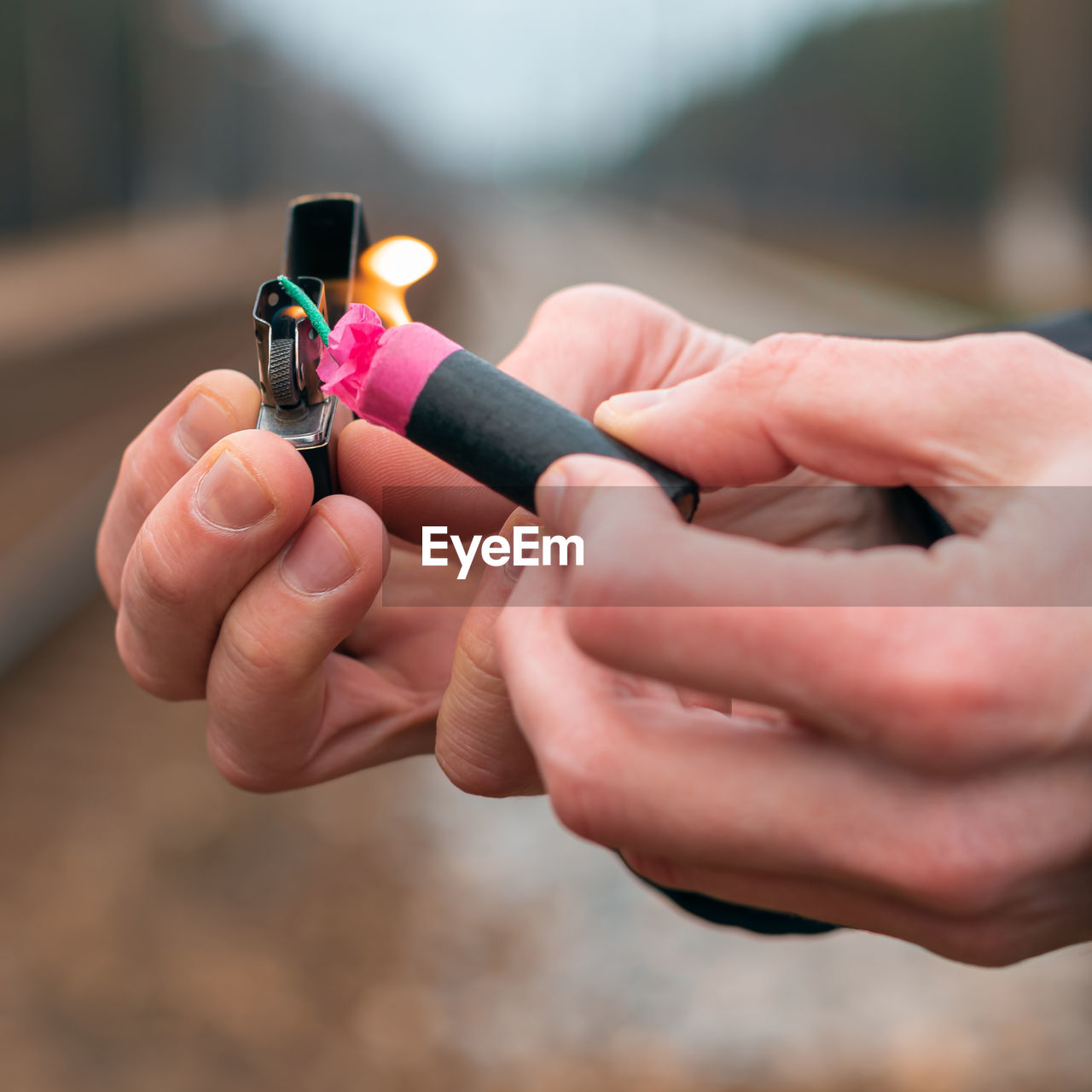 Close-up of hand holding lighter and bomb