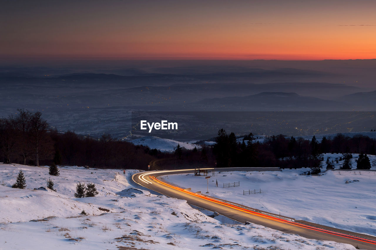 Scenic view of snowy landscape against sky during sunset