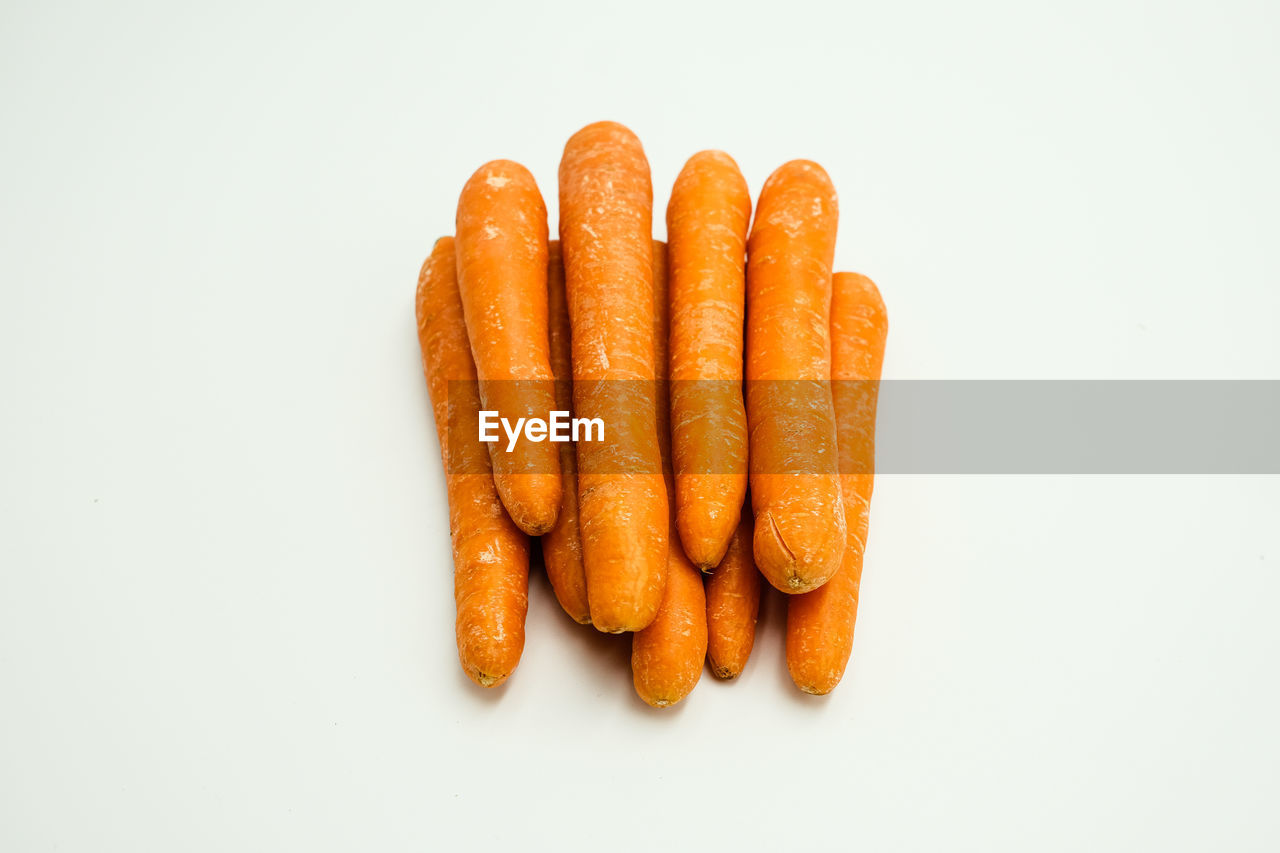 HIGH ANGLE VIEW OF CARROTS ON WHITE SURFACE