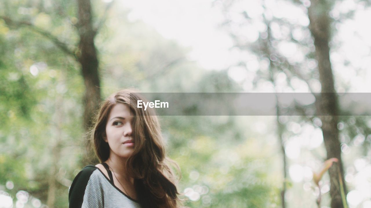 PORTRAIT OF YOUNG WOMAN IN PARK