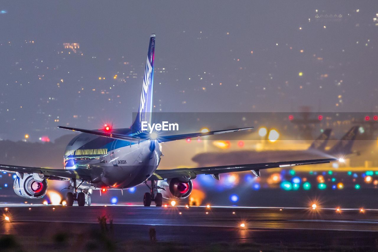 AIRPLANE ON AIRPORT RUNWAY AT NIGHT