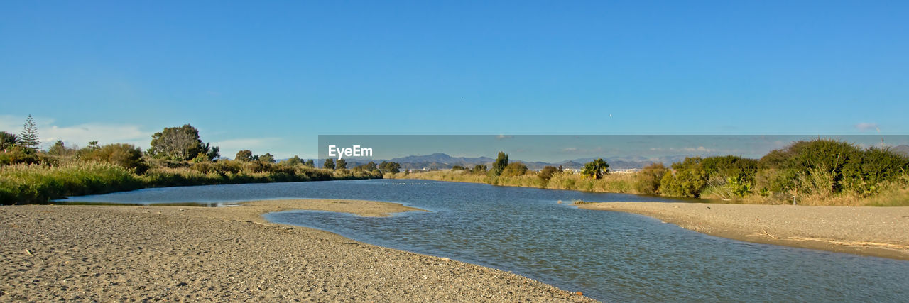 Scenic view of lake against clear blue sky