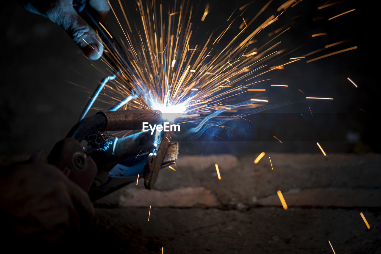 Welding of steel, sparking, not wearing gloves, light colored like fireworks.