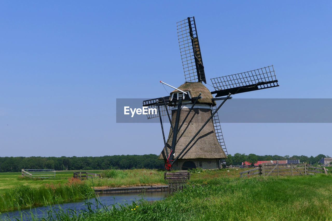 WINDMILL ON FIELD AGAINST SKY