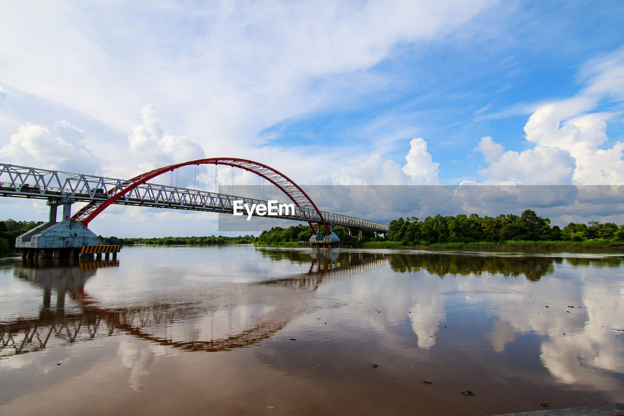 View of bridge over river against cloudy sky