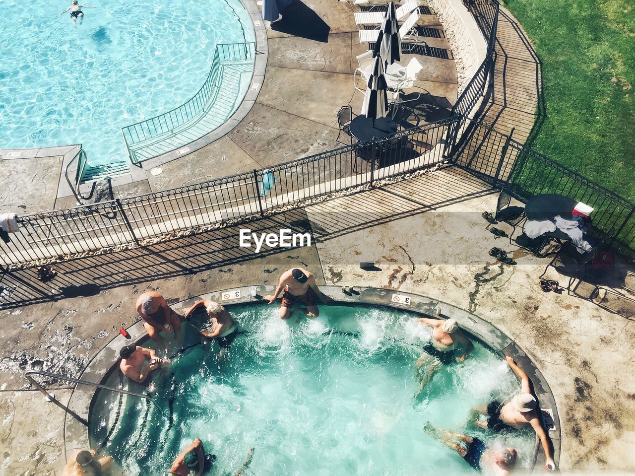 HIGH ANGLE VIEW OF PEOPLE SWIMMING IN POOL AT PARK