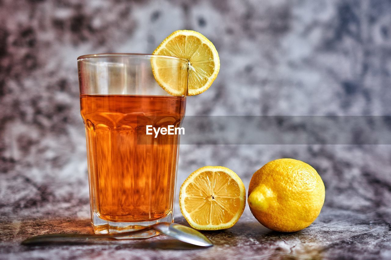 Close-up of lemon and drink on table