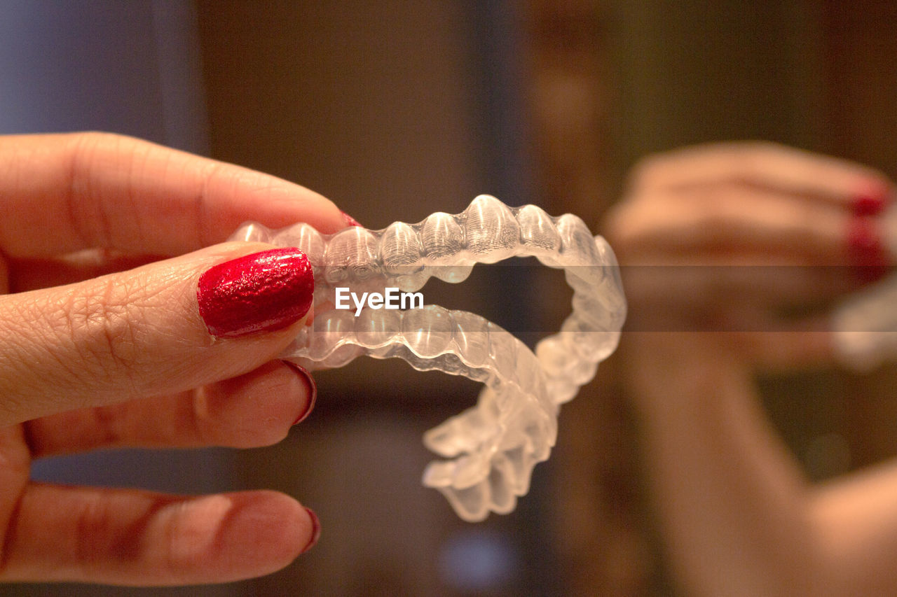 Cropped hand of woman holding dental aligner