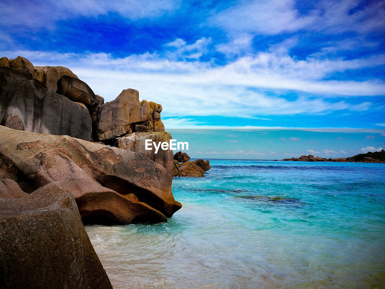 Rock formation at beach against sky