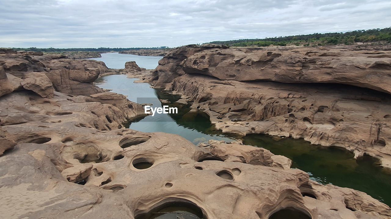 rock, water, geology, land, nature, coast, sea, environment, sky, terrain, scenics - nature, beauty in nature, cloud, landscape, wadi, beach, travel destinations, no people, formation, rock formation, cliff, travel, tranquility, sand, natural environment, outdoors, non-urban scene, day, shore, tourism