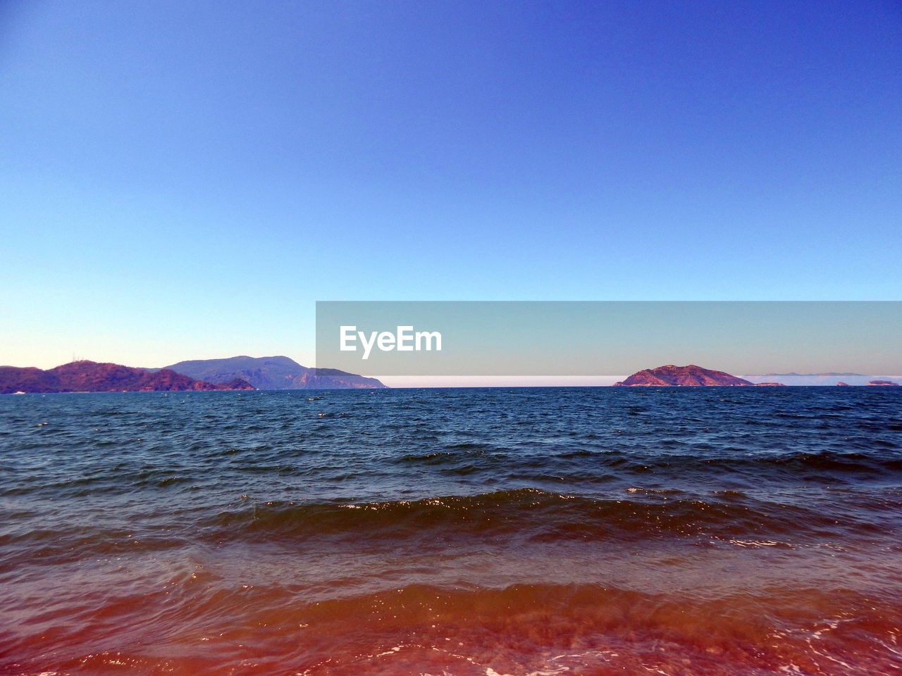 Scenic view of sea against blue sky