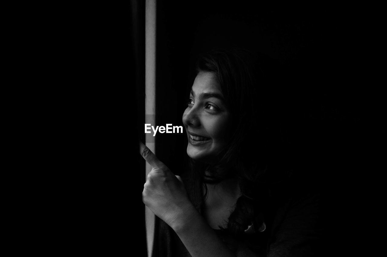 Happy young woman in darkroom looking away