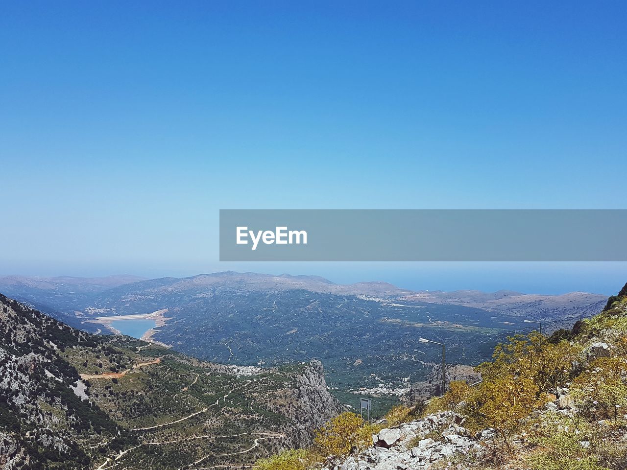 AERIAL VIEW OF MOUNTAIN AGAINST CLEAR BLUE SKY