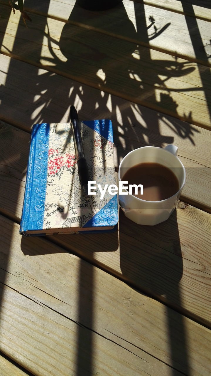 High angle view of coffee andvbook  on table