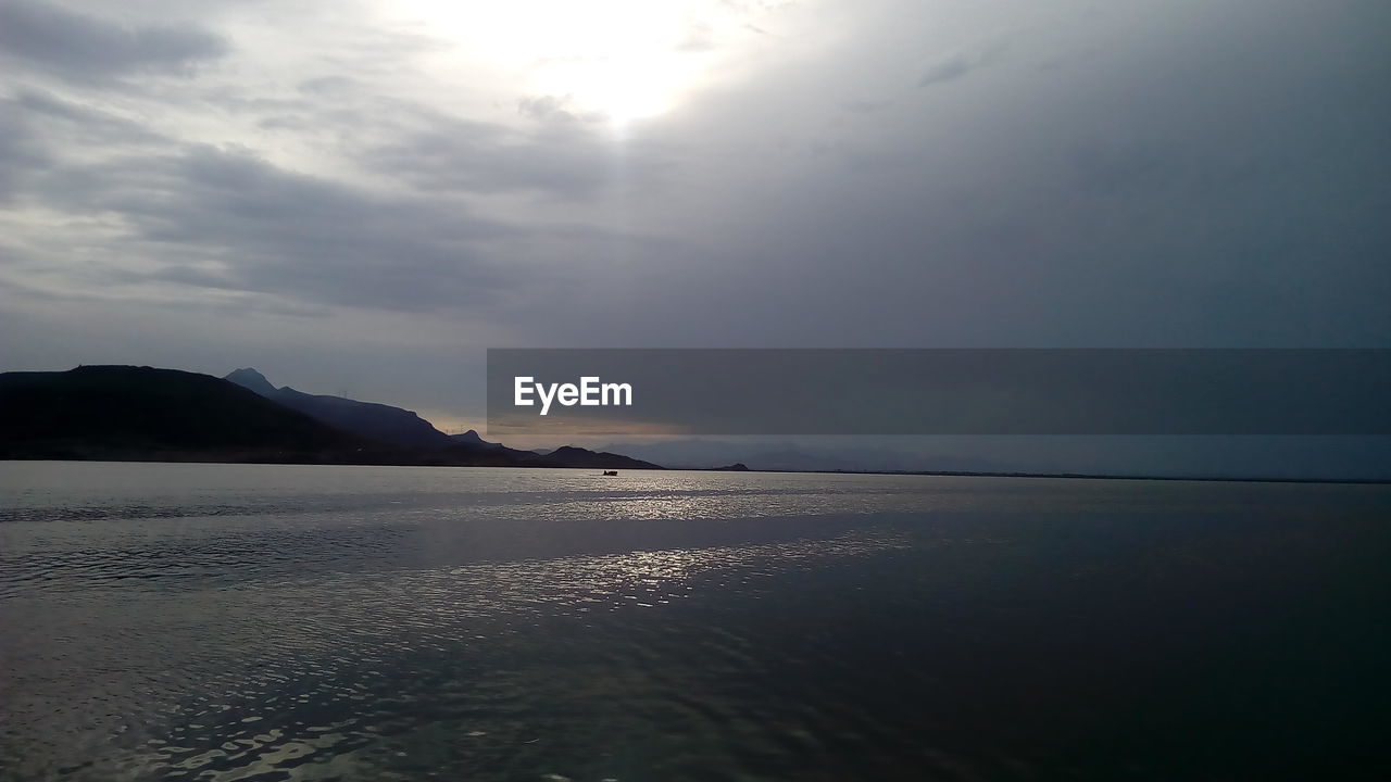 SCENIC VIEW OF SEA BY MOUNTAINS AGAINST SKY