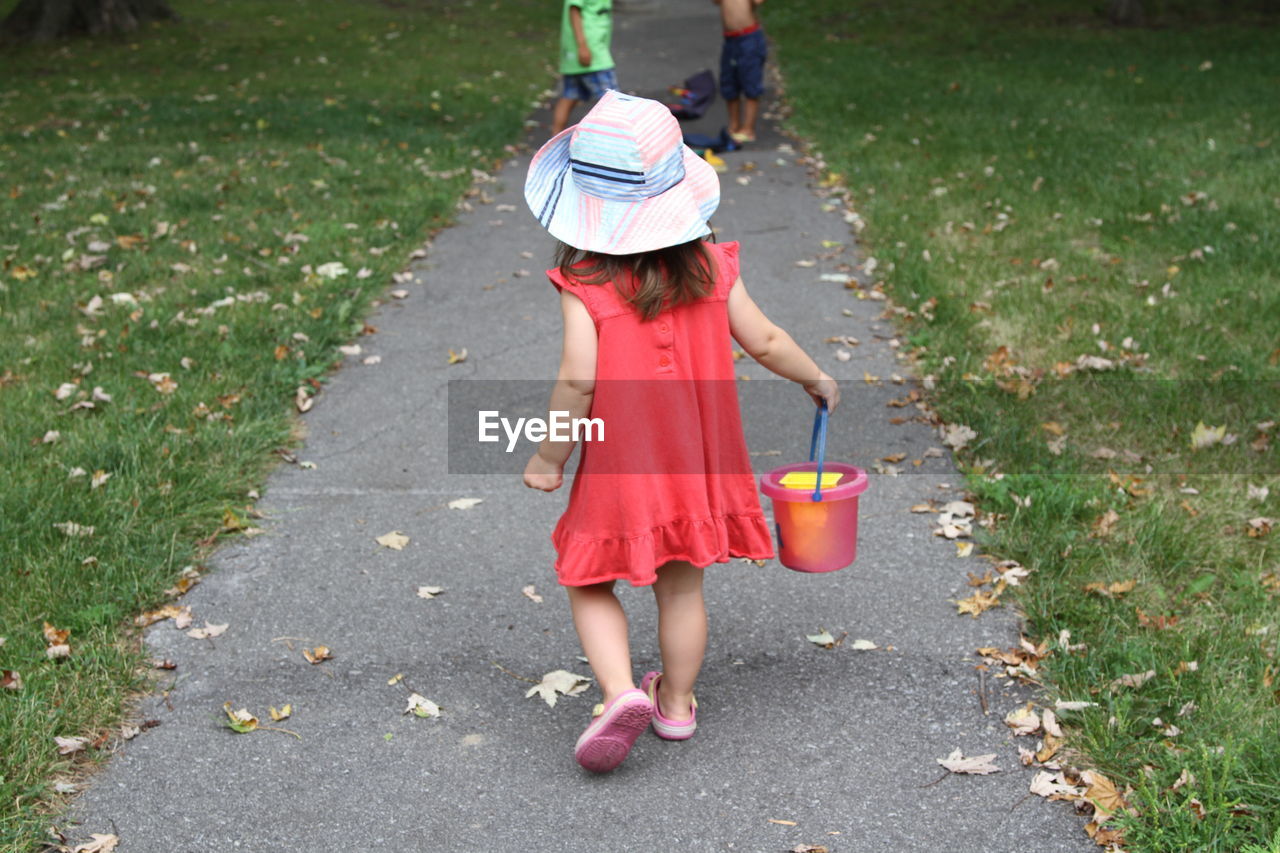 Rear view of girl walking on footpath