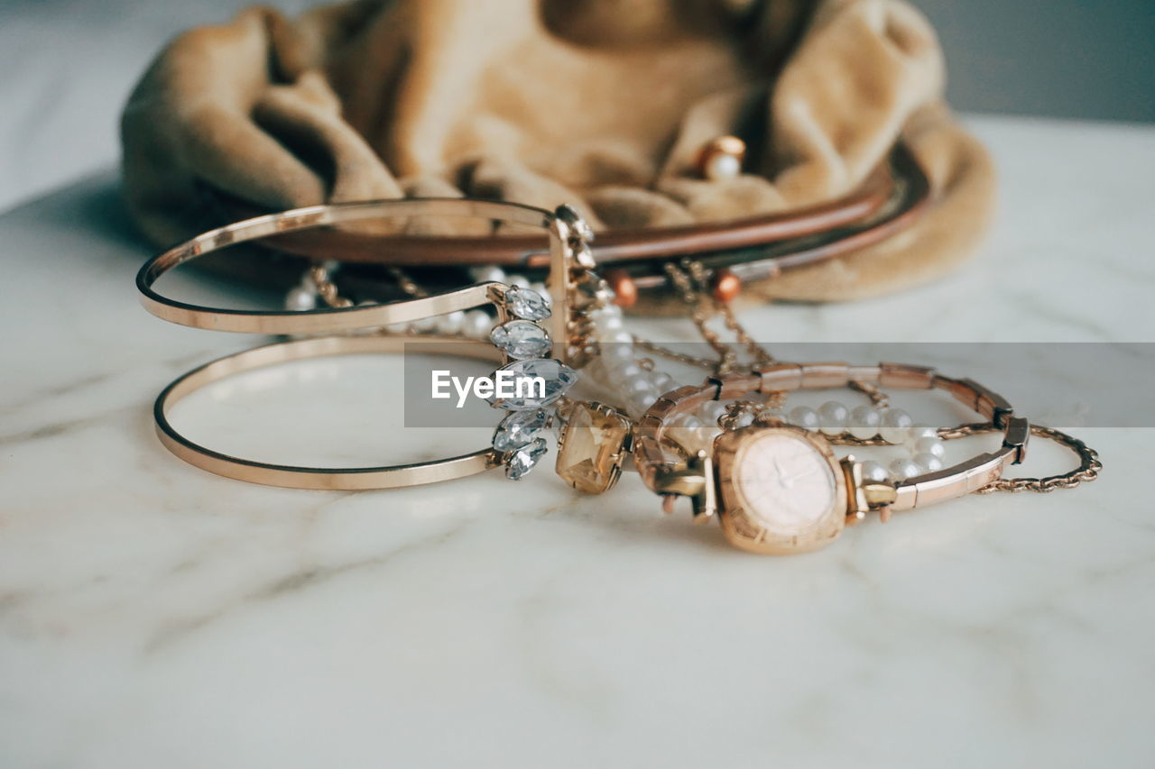 Close-up of jewelry by purse on table