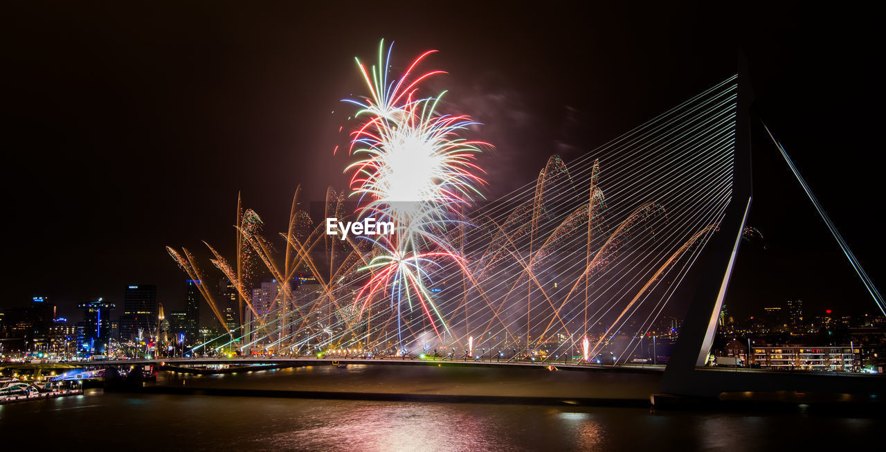 Firework exploding over erasmus bridge at night