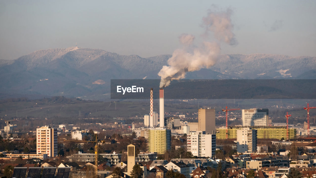 Smoke emitting from chimney against sky