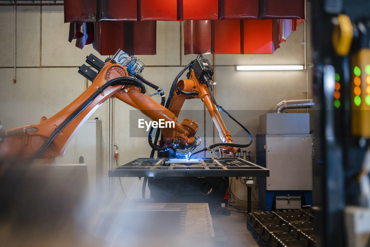Industrial robotic arms welding in factory