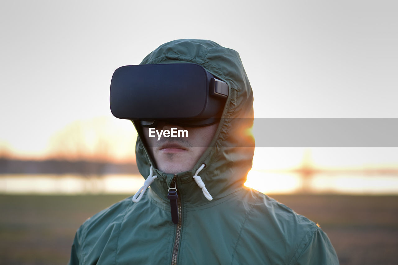 Man wearing virtual reality simulator standing on beach