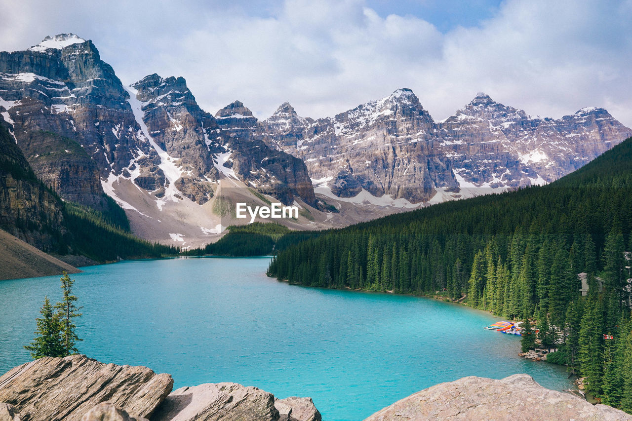 Scenic view of lake by mountains against sky