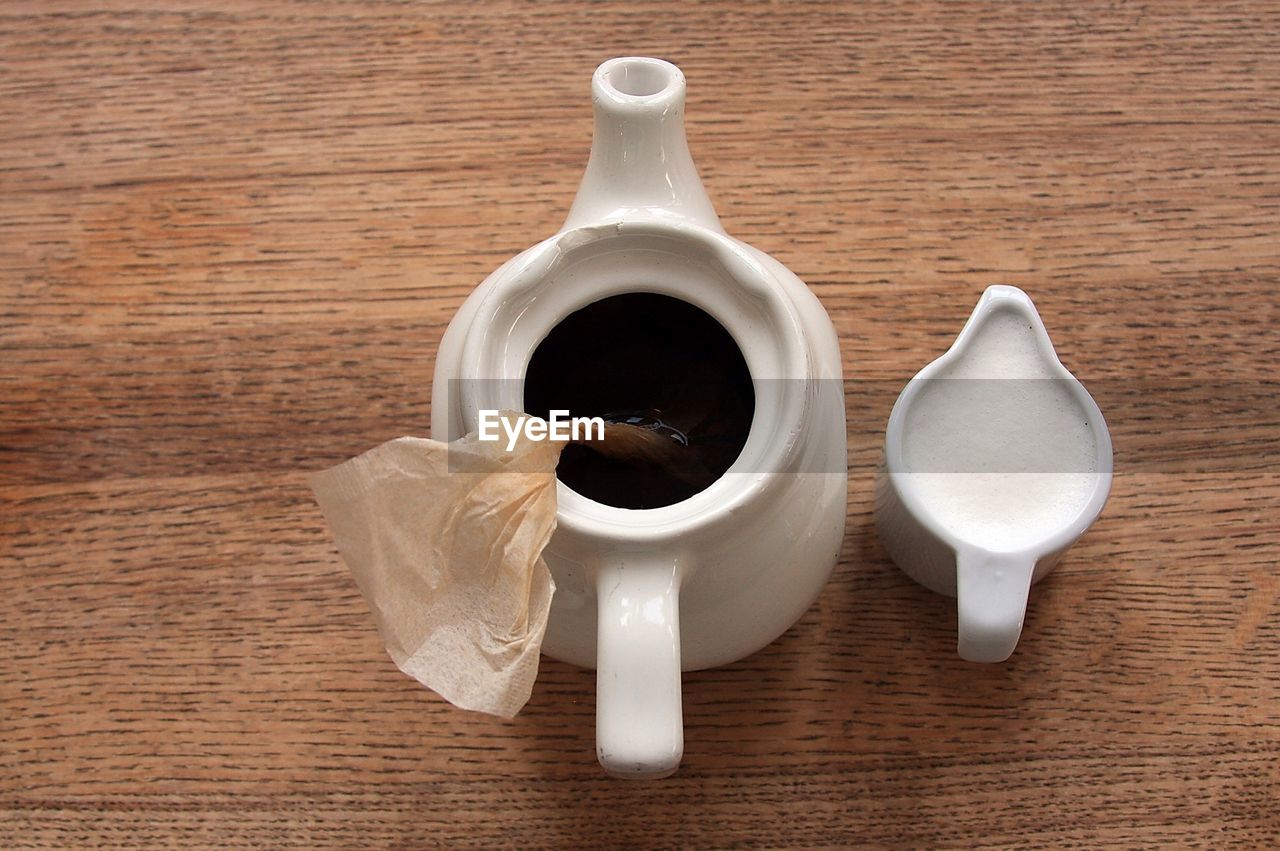 Directly above shot of teapot and powdered sugar on table