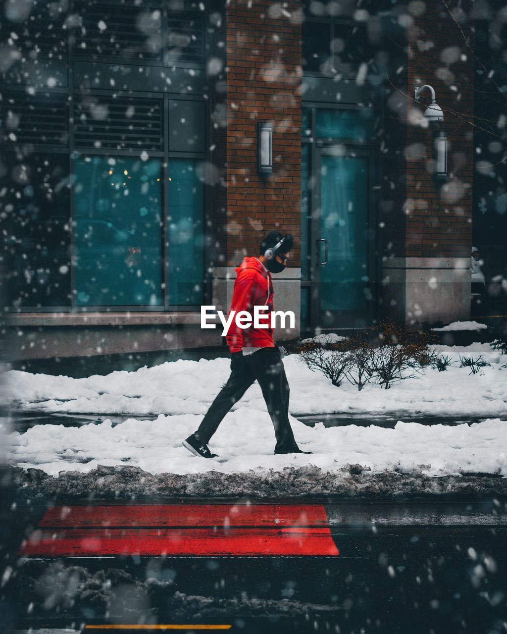 FULL LENGTH OF MAN STANDING BY SNOW IN CITY