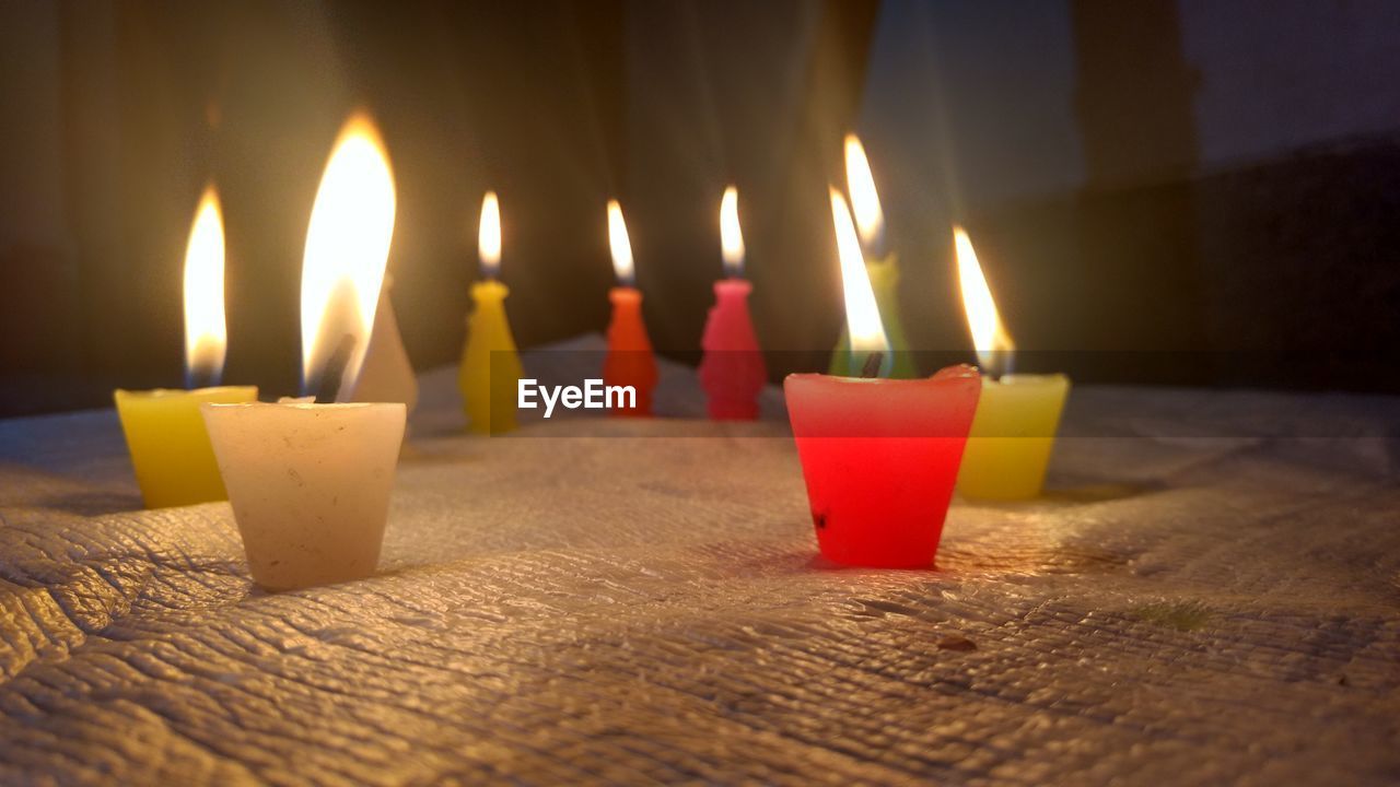 Close-up of burning candles on table