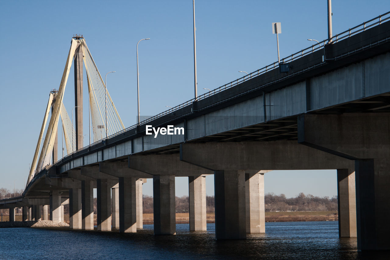 LOW ANGLE VIEW OF BRIDGE AGAINST RIVER