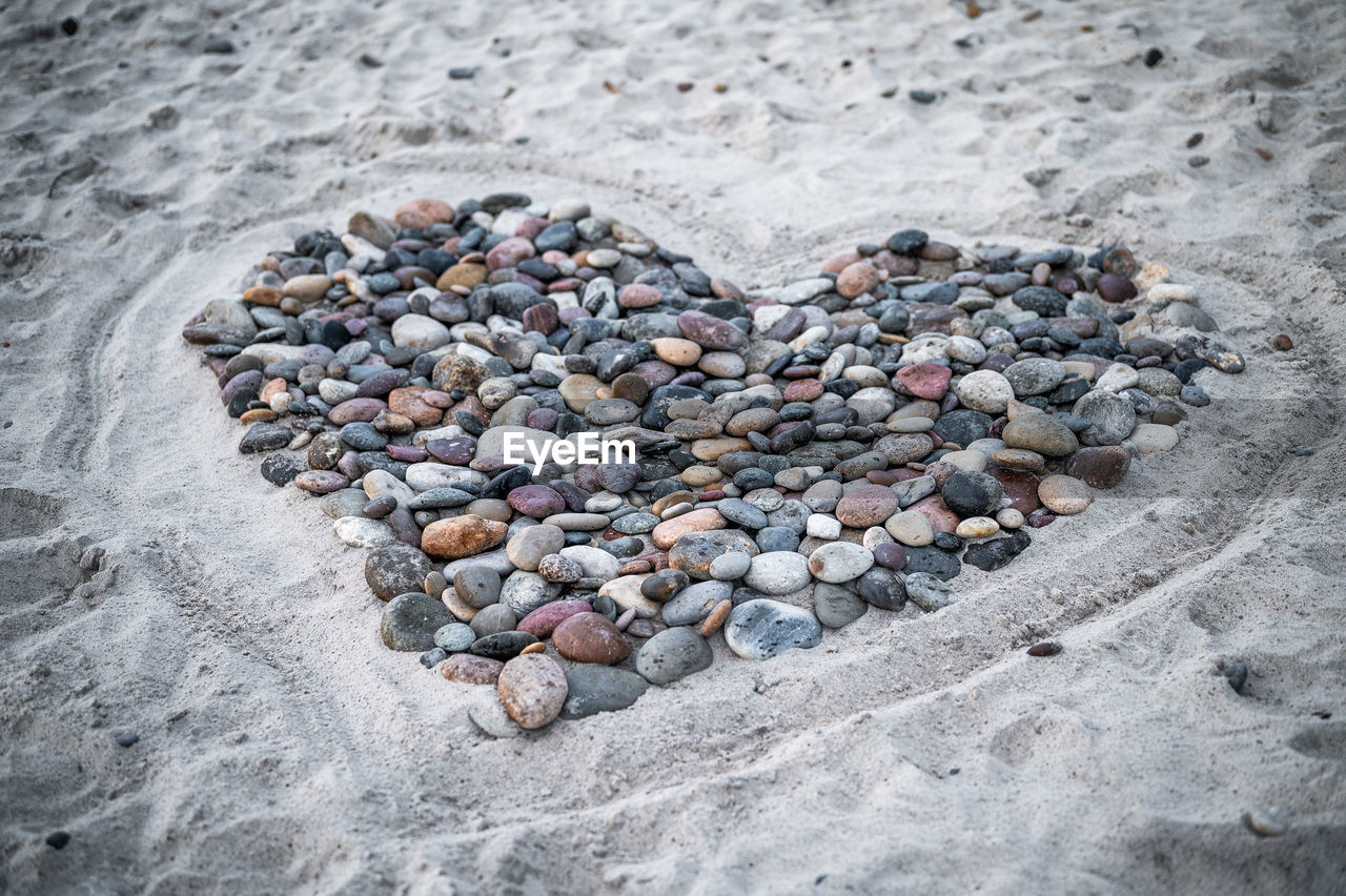 rock, beach, land, sand, high angle view, pebble, nature, no people, stone, day, large group of objects, outdoors, heart shape, abundance, geology, soil
