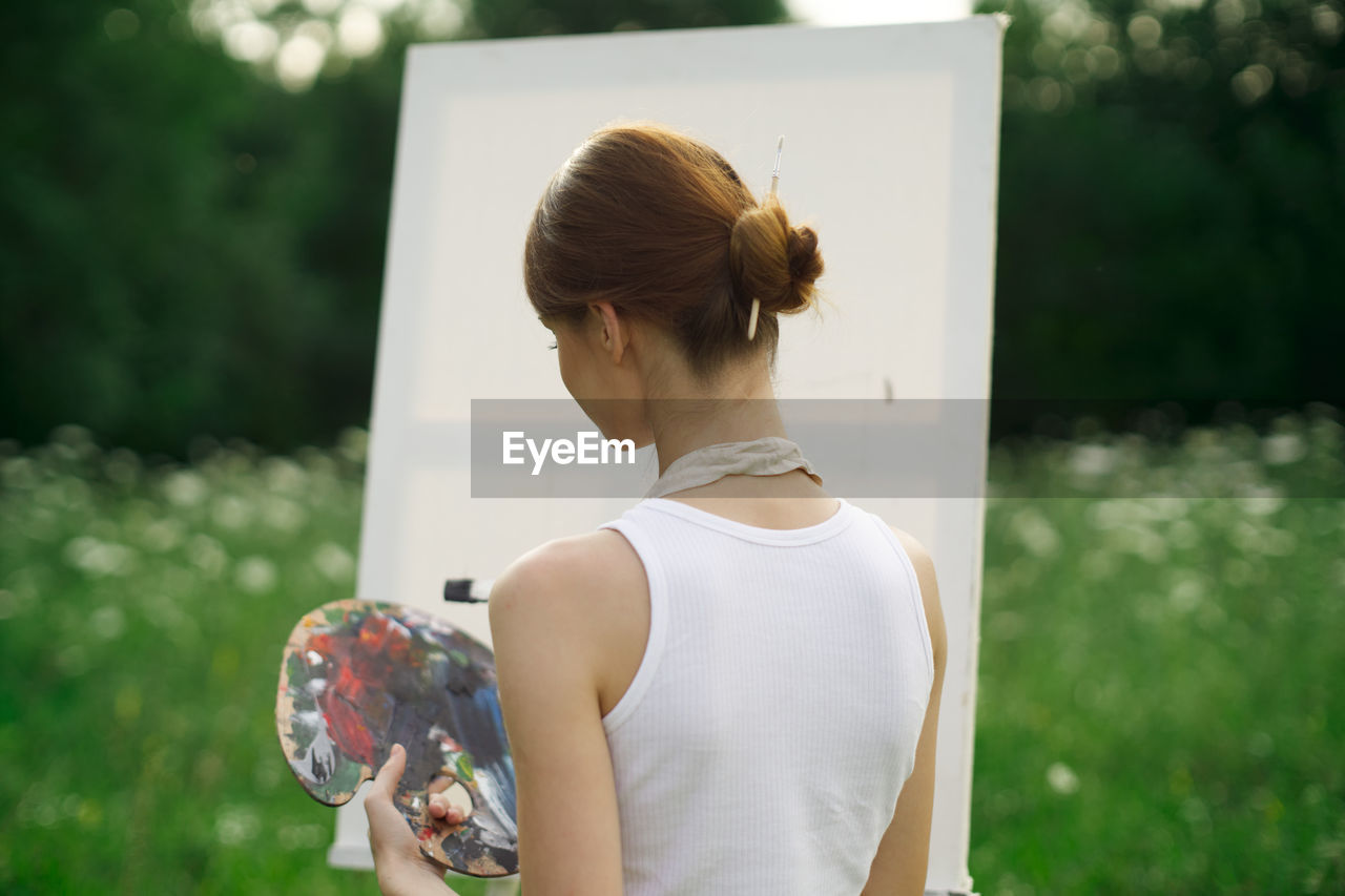 REAR VIEW OF WOMAN WITH UMBRELLA