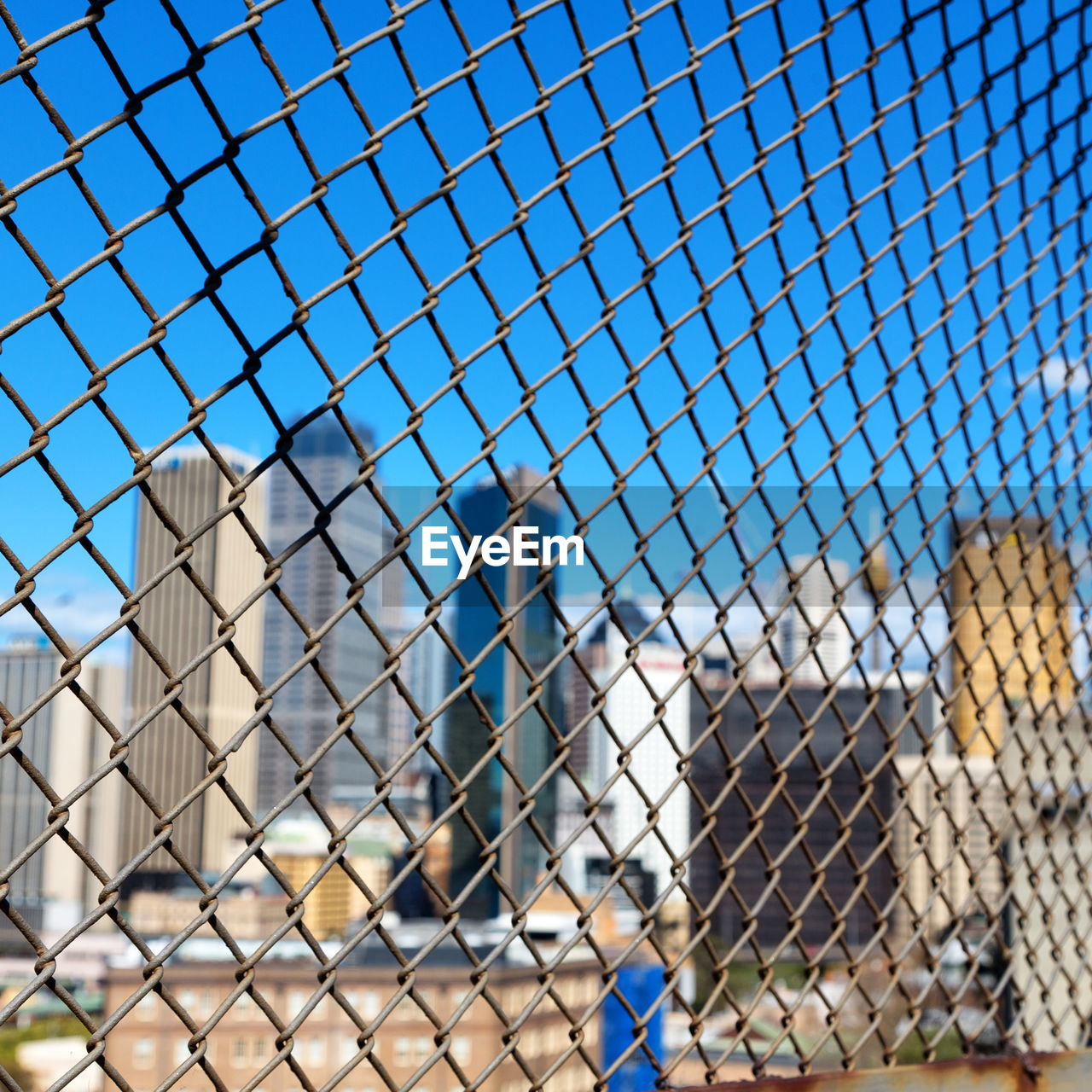 CLOSE-UP OF CHAINLINK FENCE AGAINST SKY