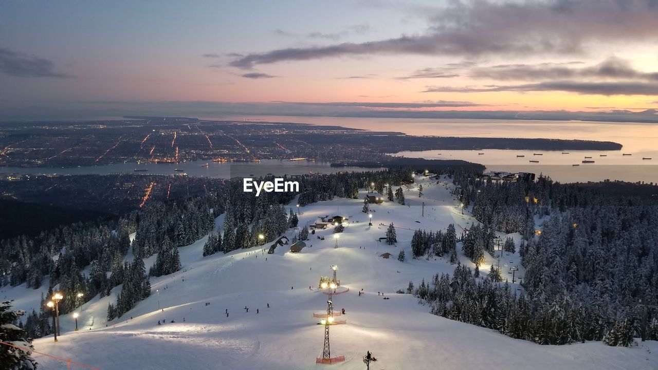 High angle view of illuminated snowcapped mountain against sky during sunset