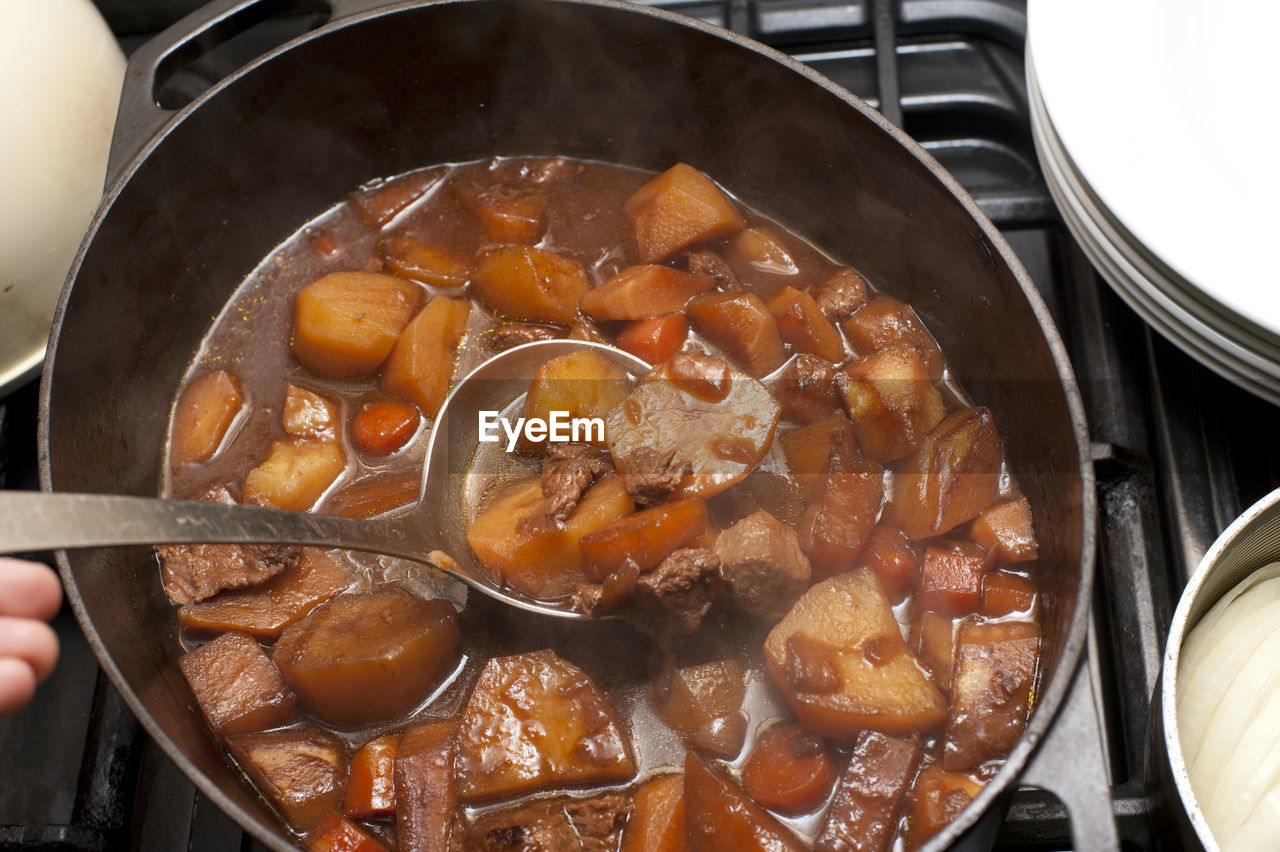 Close-up of beef stew in container on burner