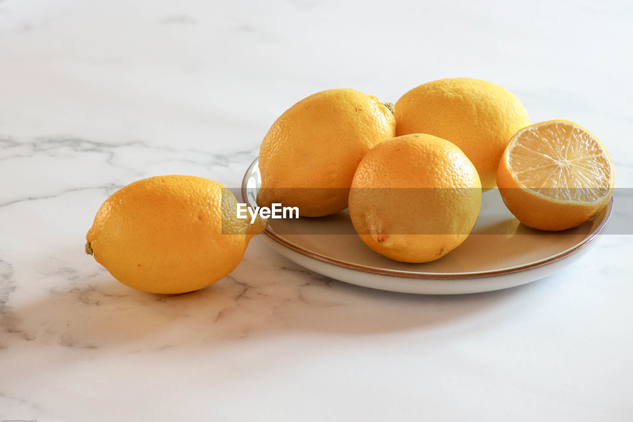 High angle view of lemon fruits in plate on table