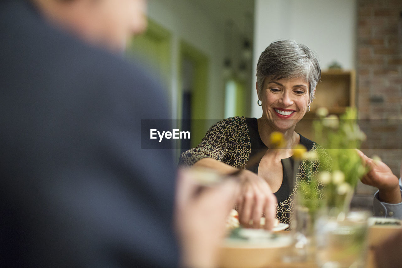 Smiling woman at table during social gathering