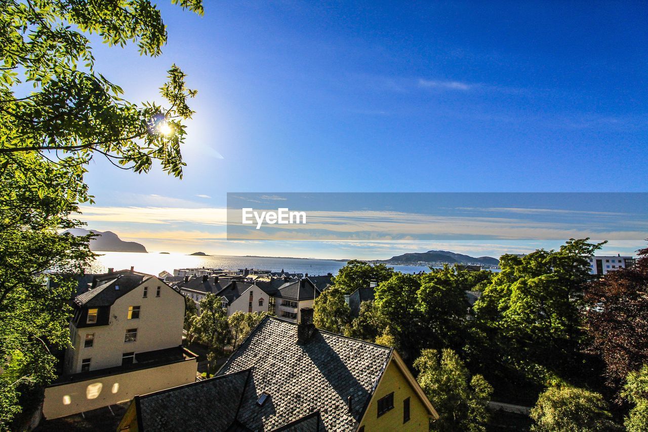 HIGH ANGLE VIEW OF BUILDINGS AGAINST BLUE SKY