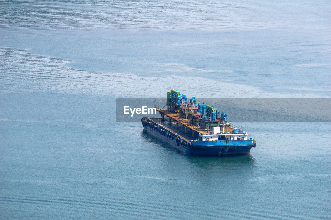 HIGH ANGLE VIEW OF BOAT SAILING IN SEA