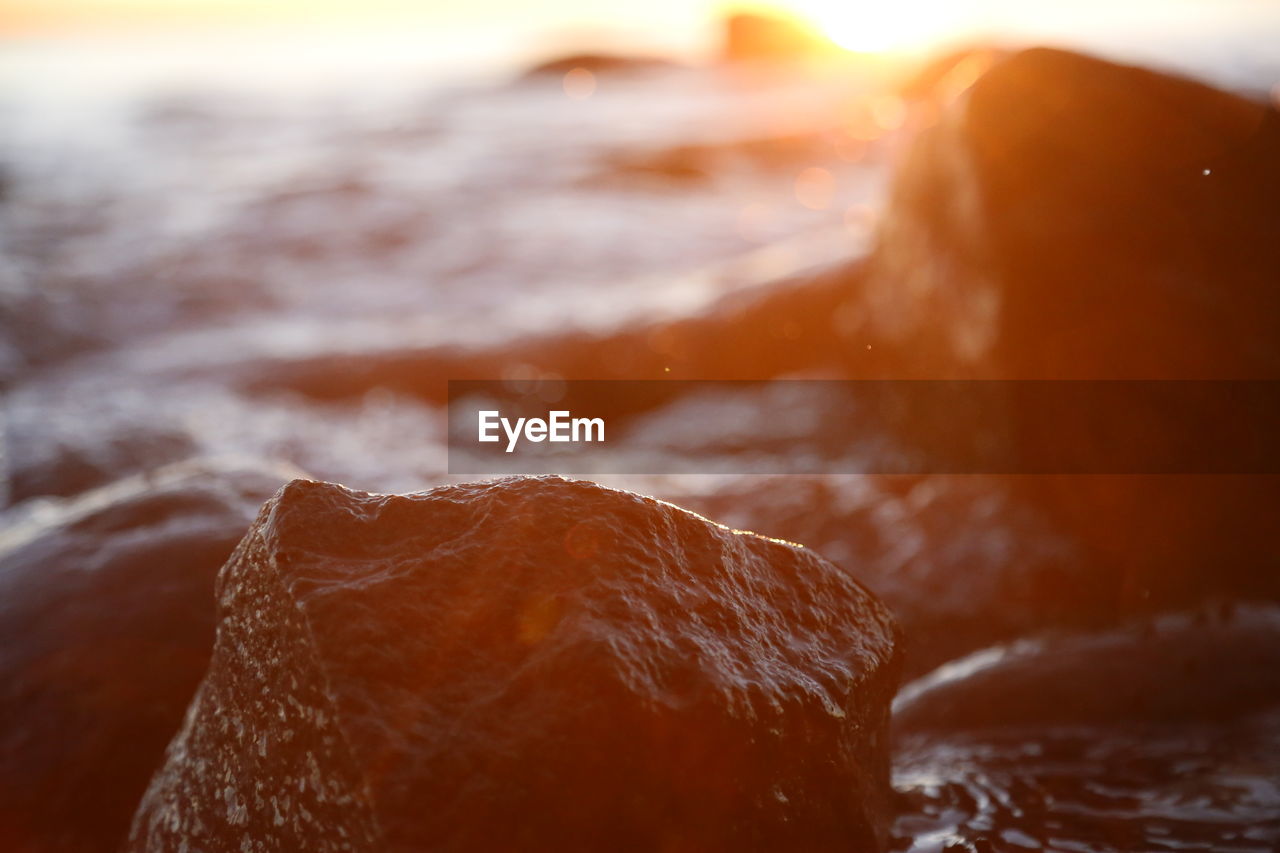 Stony beach stones and rocks sunlit in the evening closeup, texture sunset and sunrise