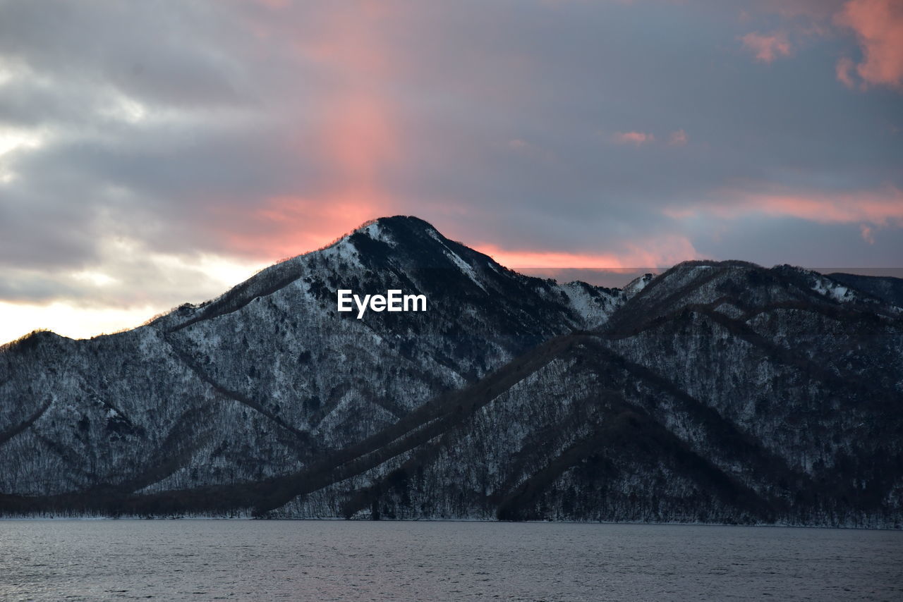 Scenic view of snowcapped mountains against sky during sunset