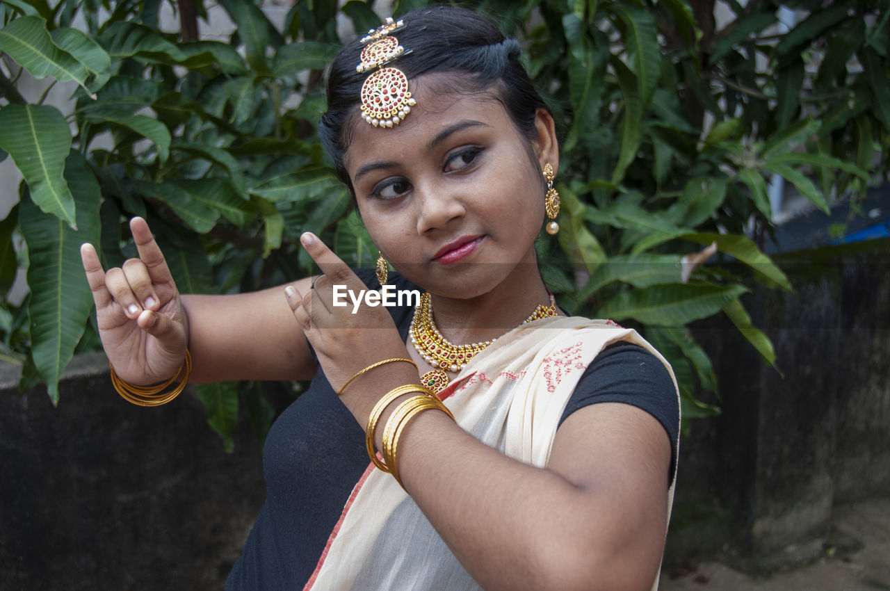 A teenage girl practicing bharatnatyam in nature