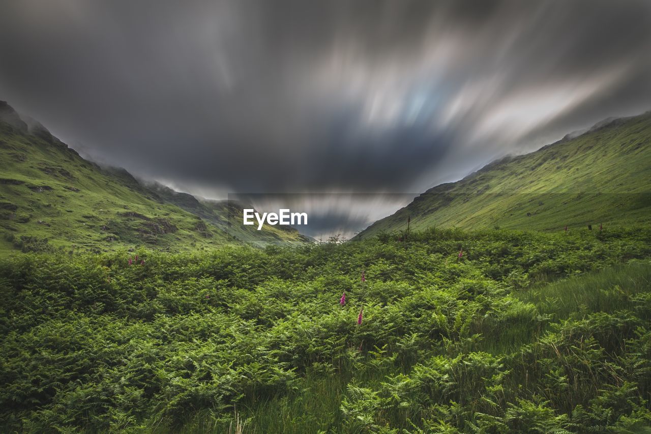 Scenic view of green mountains against sky