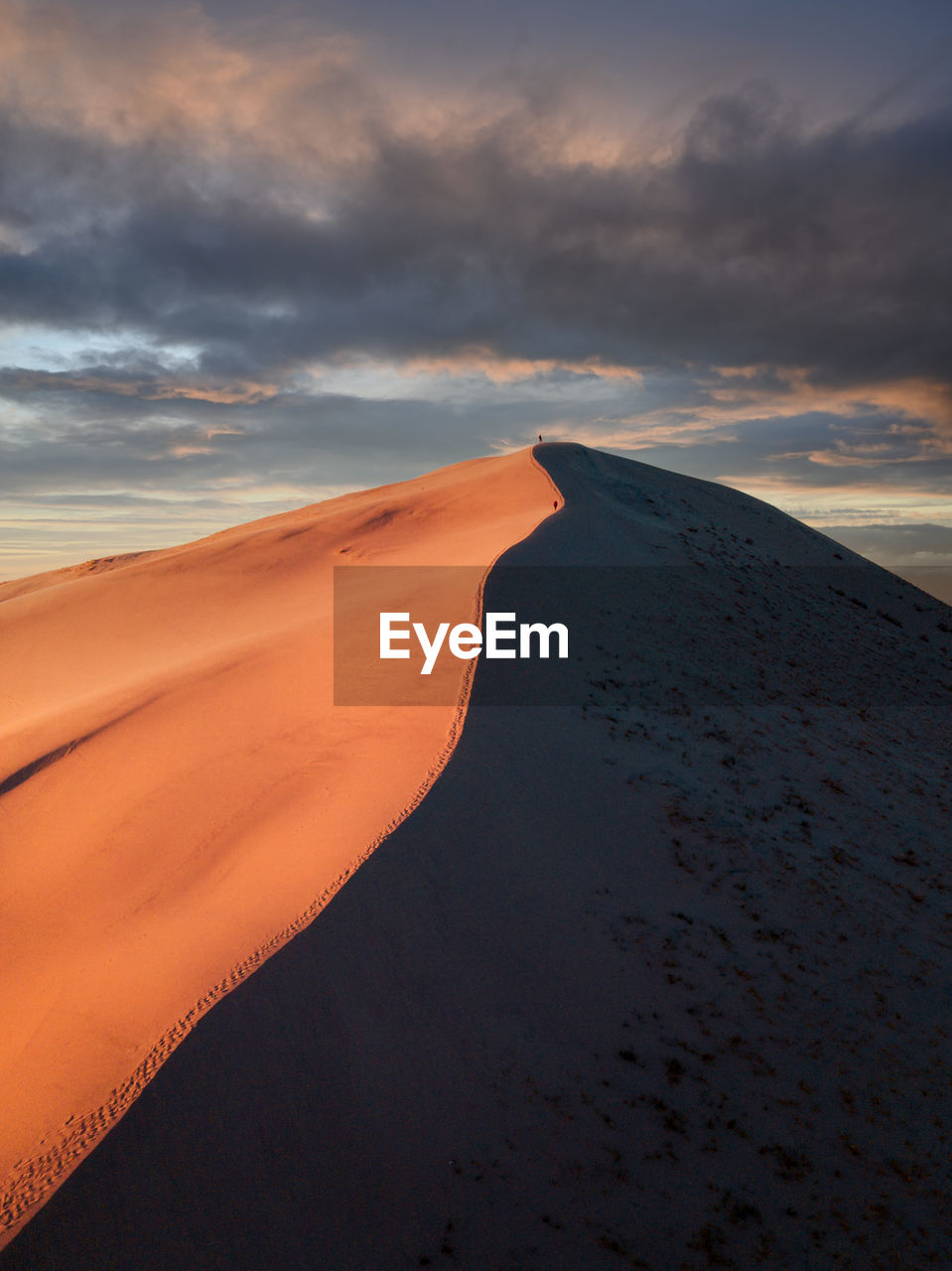 Scenic view of dunes against sky during sunset