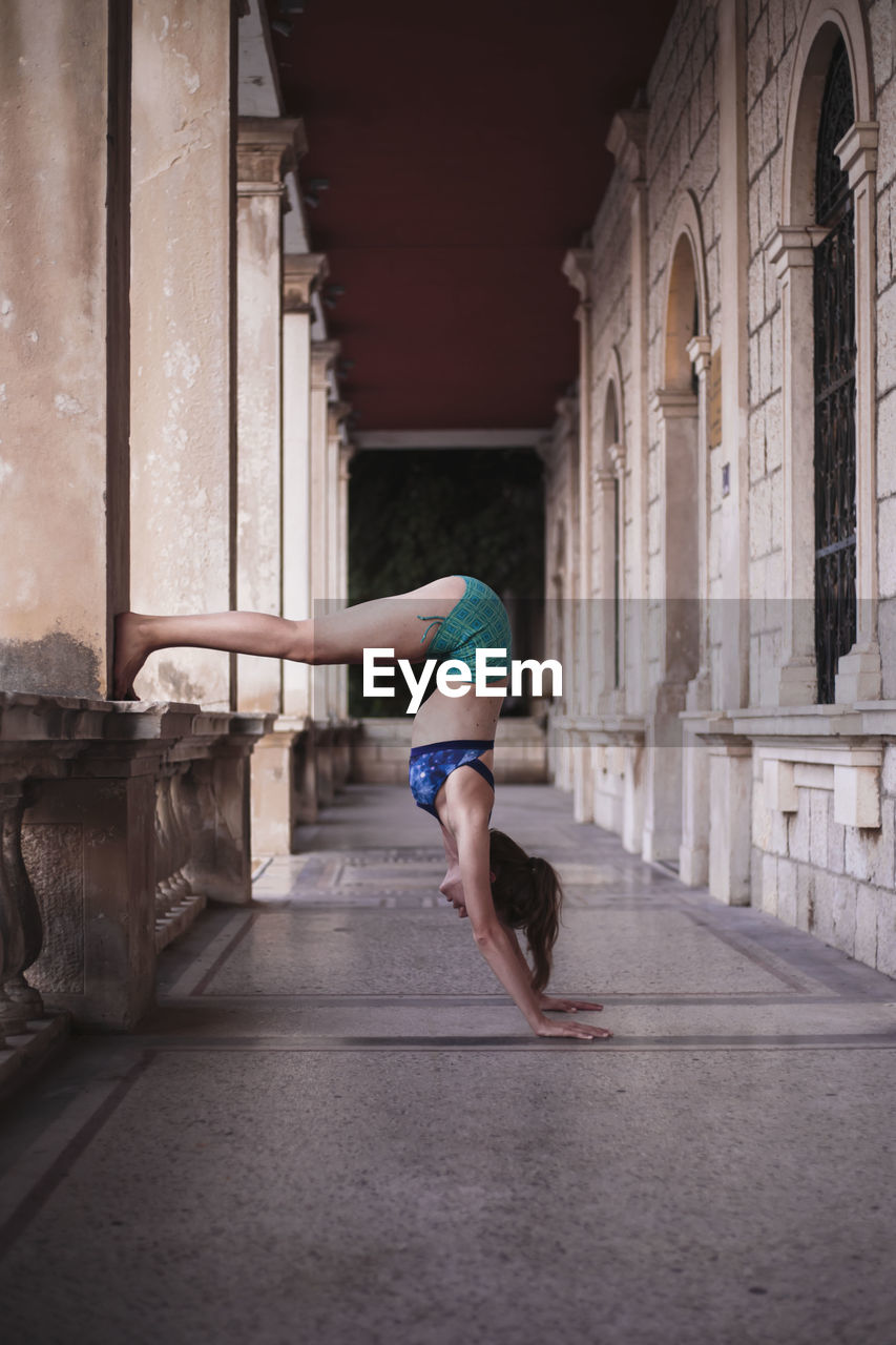 Side view of woman exercising in corridor