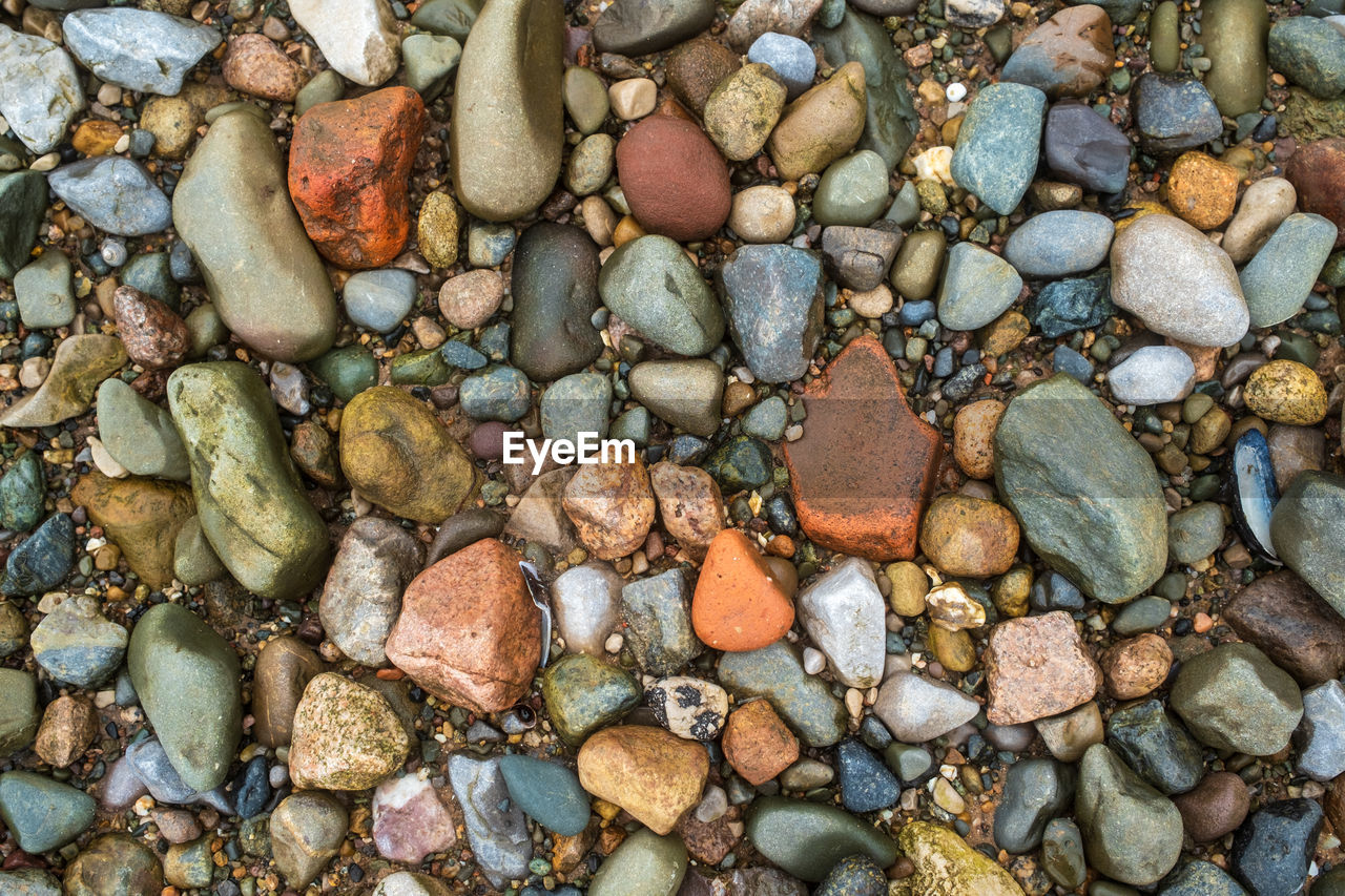 HIGH ANGLE VIEW OF STONES ON PEBBLES