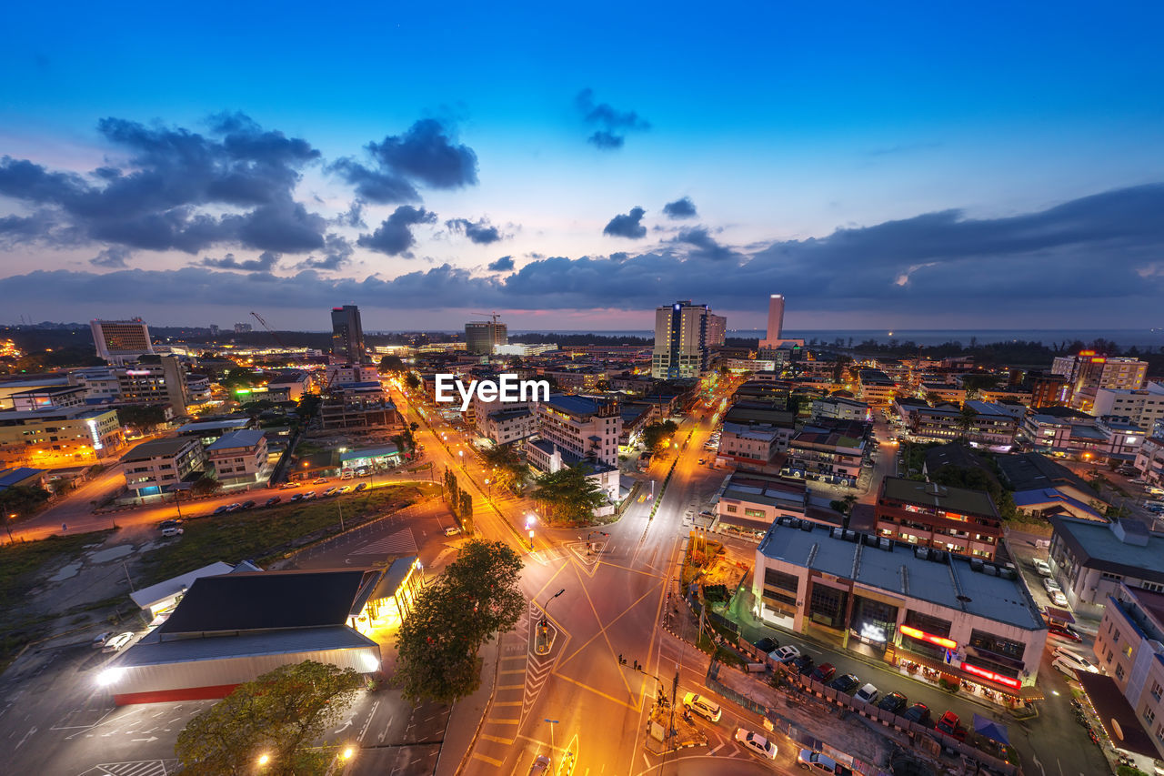 HIGH ANGLE VIEW OF ILLUMINATED CITY BUILDINGS AGAINST SKY